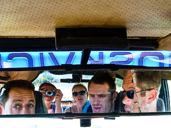 Passengers in taxi rearview mirror